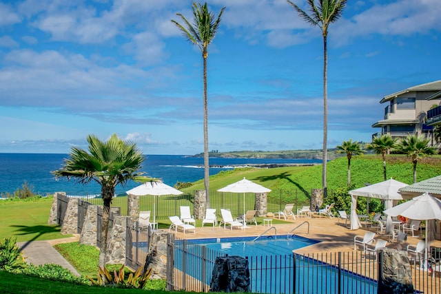 view of swimming pool with a lawn, a patio area, and a water view