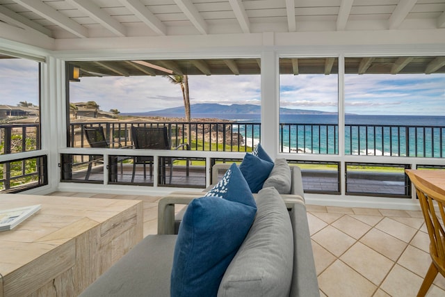 sunroom / solarium featuring beam ceiling, wooden ceiling, plenty of natural light, and a water and mountain view