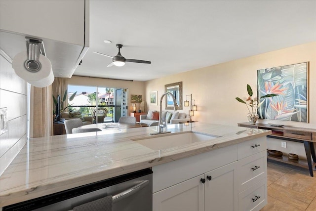 kitchen featuring white cabinets, sink, stainless steel dishwasher, ceiling fan, and light stone countertops