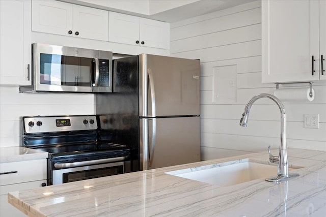 kitchen featuring light stone countertops, white cabinets, and appliances with stainless steel finishes