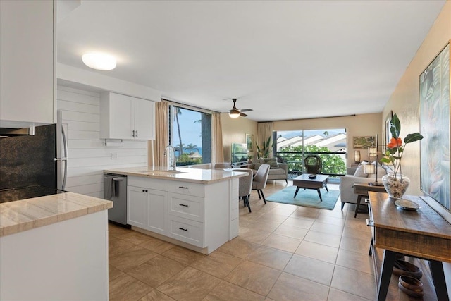 kitchen featuring dishwasher, refrigerator, sink, ceiling fan, and white cabinetry