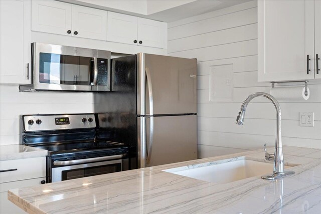 2737 S Kihei Rd Unit 160, Kihei, HI 96753 - kitchen with appliances with stainless steel finishes, a sink, white cabinets, and light stone countertops