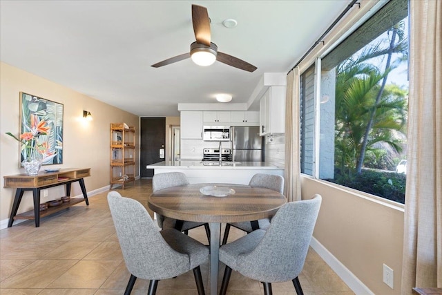 tiled dining room with ceiling fan and plenty of natural light