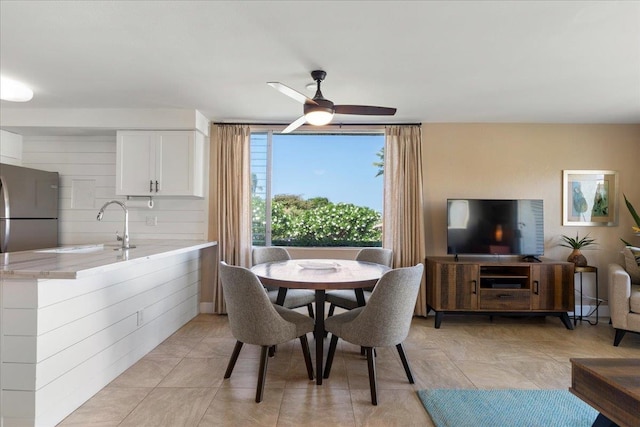 dining room featuring light tile patterned flooring, ceiling fan, and sink