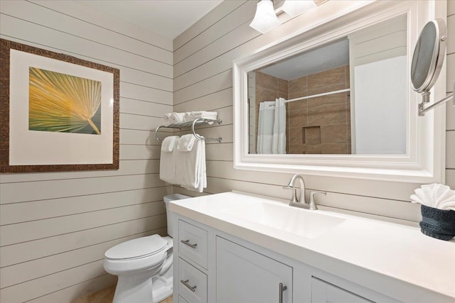 bathroom with vanity, toilet, curtained shower, and wood walls