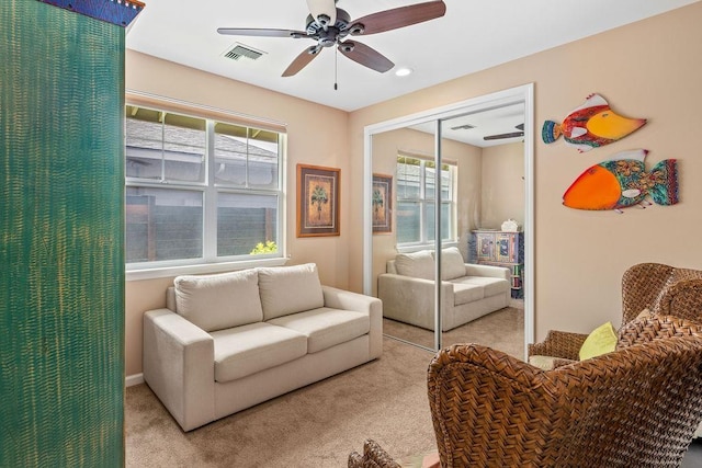 living room featuring light carpet, ceiling fan, and plenty of natural light