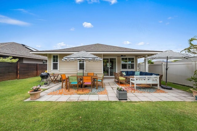 back of house with an outdoor living space, a lawn, and a patio