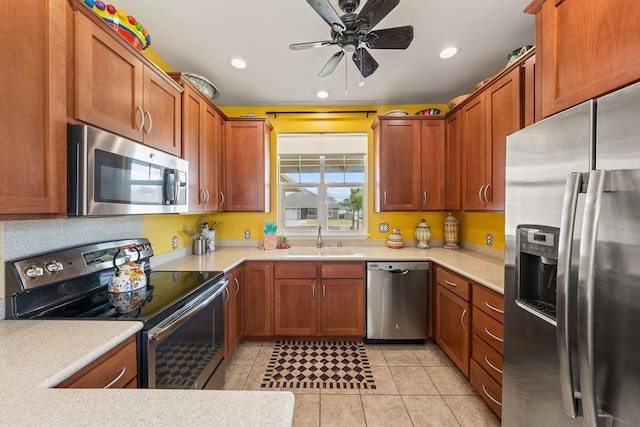 kitchen with ceiling fan, appliances with stainless steel finishes, sink, and light tile patterned flooring