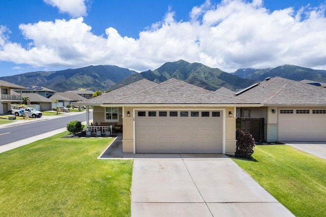 ranch-style home with a front yard, a mountain view, and a garage