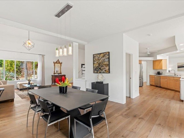 dining space with sink and light wood-type flooring