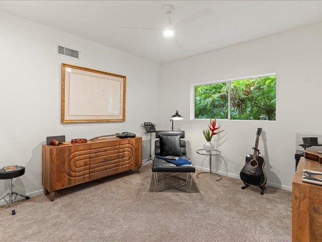 living area with ceiling fan and light colored carpet