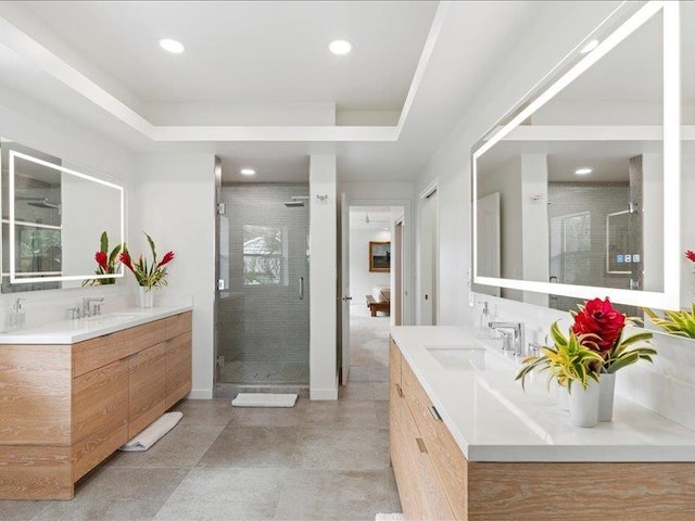 bathroom with a shower with door and vanity