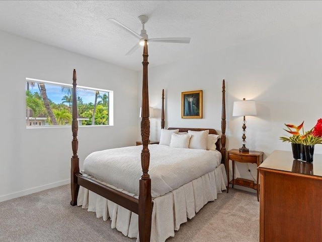 bedroom with ceiling fan, a textured ceiling, and light carpet