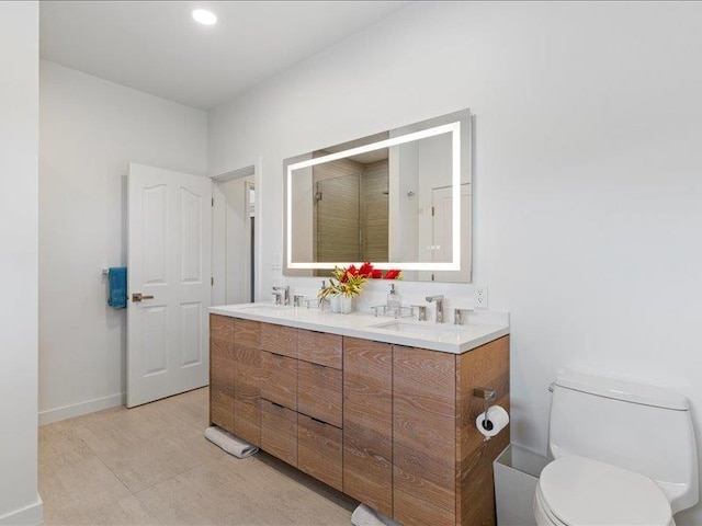 bathroom featuring vanity, toilet, and a shower with door