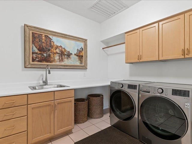 clothes washing area featuring sink, independent washer and dryer, cabinets, and light tile patterned floors