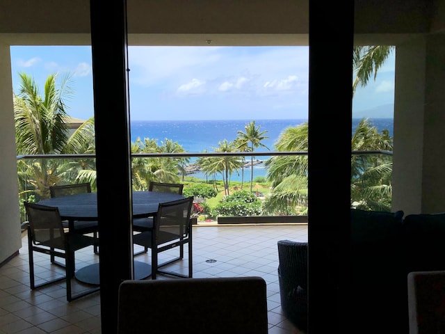 interior space with light tile patterned floors and a water view