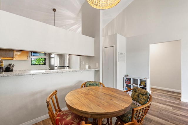 15 Kulanihakoi St Unit 9F, Kihei, HI 96753 - dining room featuring baseboards, light wood finished floors, and a towering ceiling