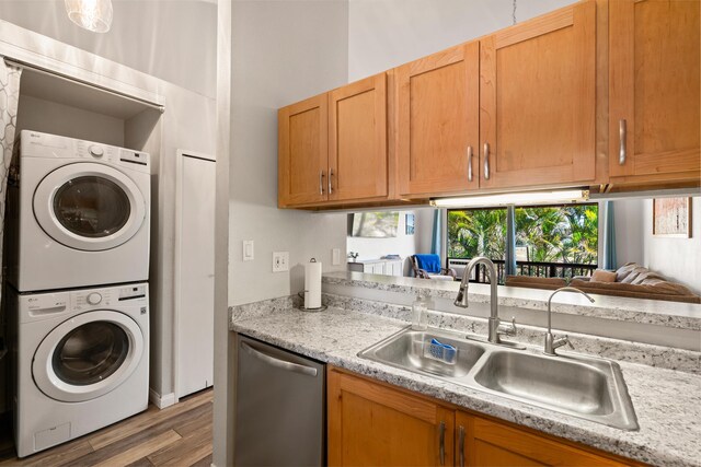 15 Kulanihakoi St Unit 9F, Kihei, HI 96753 - kitchen with a sink, stainless steel dishwasher, stacked washer / dryer, light countertops, and wood finished floors