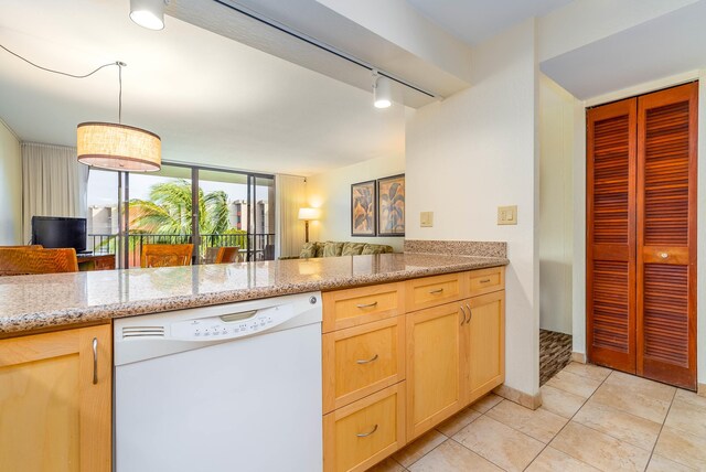 kitchen featuring white dishwasher, light tile floors, light stone countertops, rail lighting, and light brown cabinetry