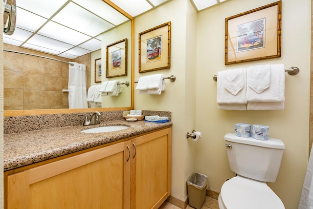 bathroom featuring tile flooring, toilet, and vanity