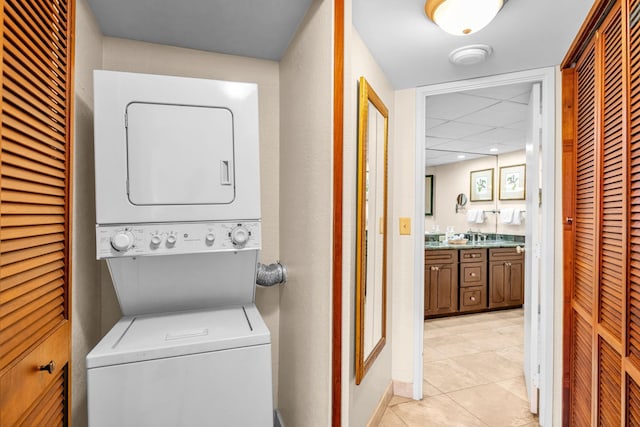 3445 Lower Honoapiilani Rd Unit 311, Lahaina, HI 96761 - clothes washing area featuring stacked washer and clothes dryer, light tile patterned floors, and baseboards