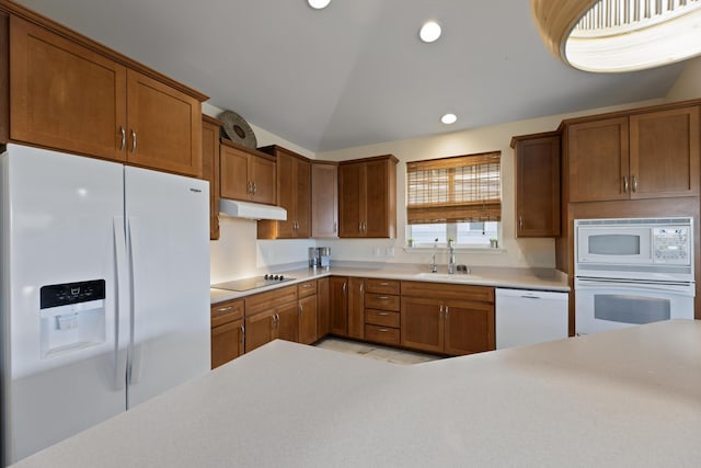 kitchen with lofted ceiling, sink, and white appliances