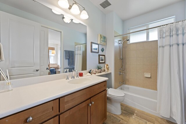 full bathroom featuring toilet, vanity, and shower / bathtub combination with curtain