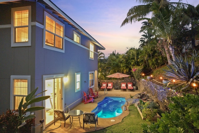 pool at dusk with a patio