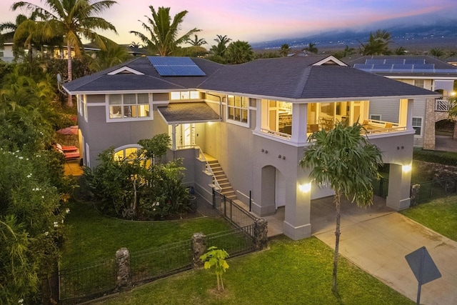 view of front of home with a lawn and solar panels