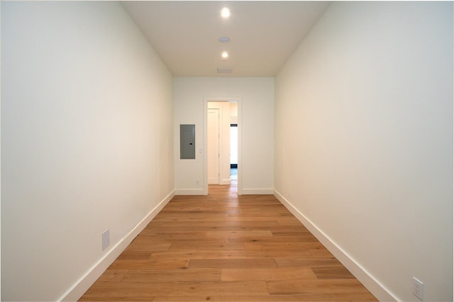 hallway featuring electric panel, visible vents, baseboards, light wood-style floors, and recessed lighting