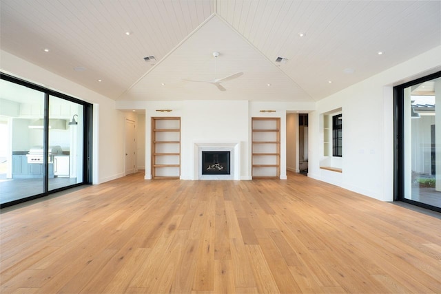 unfurnished living room featuring built in shelves, wooden ceiling, light wood-style flooring, a fireplace, and vaulted ceiling