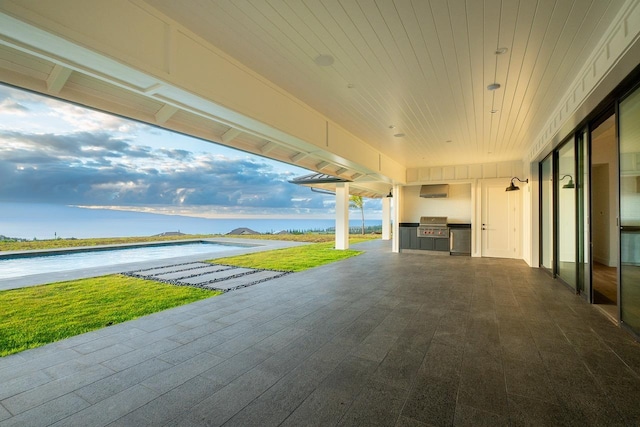 view of patio / terrace with area for grilling, an outdoor kitchen, and a water view