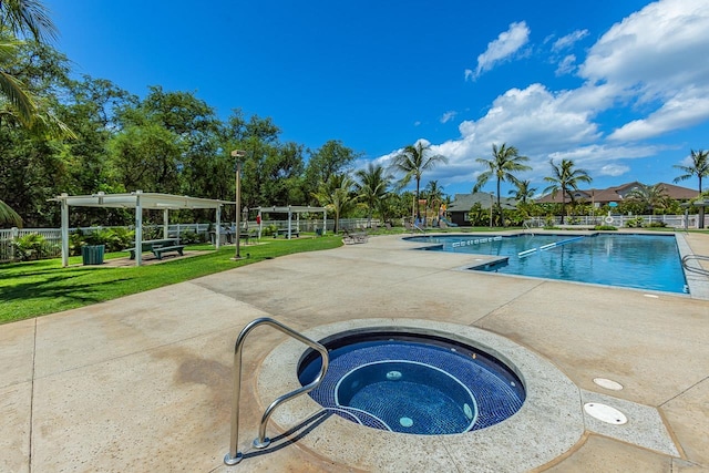 view of swimming pool with a patio, a lawn, and an in ground hot tub