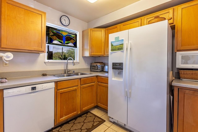 kitchen featuring white appliances, sink, and light tile patterned flooring