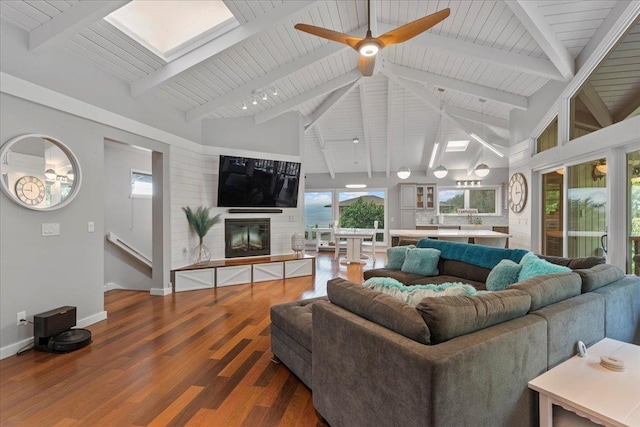 living room featuring beam ceiling, hardwood / wood-style flooring, plenty of natural light, and ceiling fan