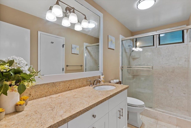 bathroom with tile patterned flooring, vanity, a shower with shower door, and toilet