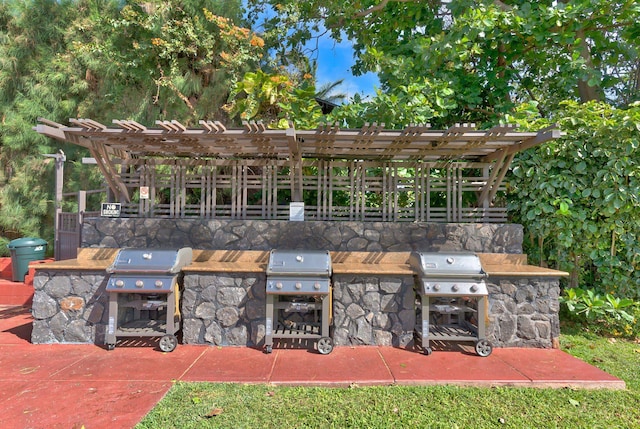 view of patio / terrace featuring a pergola, area for grilling, and exterior kitchen