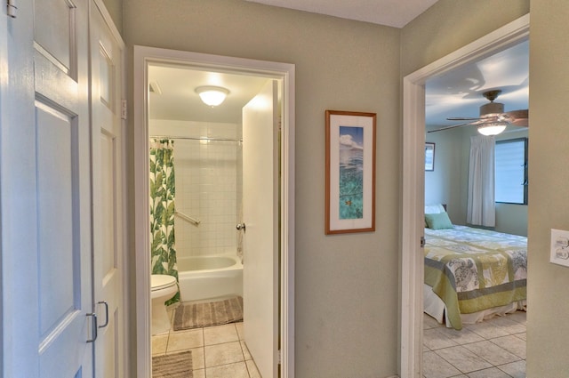 interior space featuring tile patterned floors, shower / bath combo, ceiling fan, and toilet