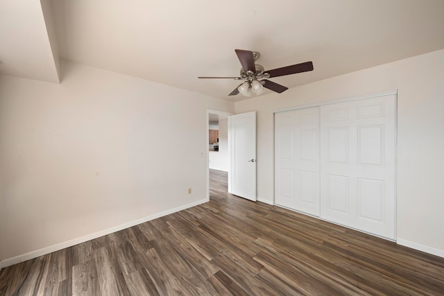 unfurnished bedroom featuring dark hardwood / wood-style flooring, ceiling fan, and a closet