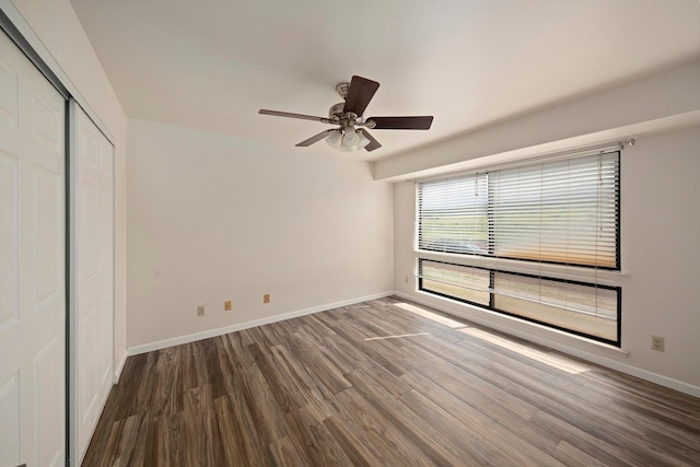 unfurnished bedroom with a closet, ceiling fan, and dark wood-type flooring