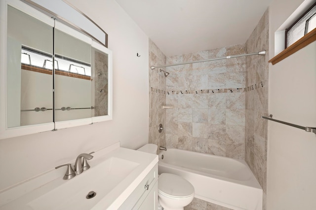 full bathroom with tiled shower / bath, toilet, oversized vanity, and a wealth of natural light