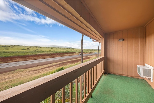 balcony with a wall unit AC and a rural view