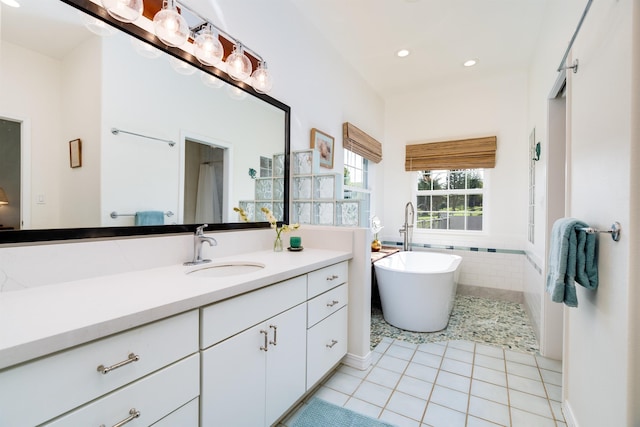 bathroom with tile patterned flooring, vanity, and a bathtub