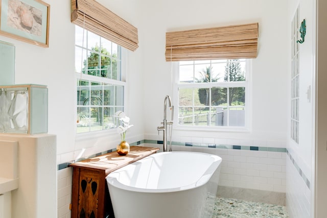 bathroom with tile walls, sink, and a tub