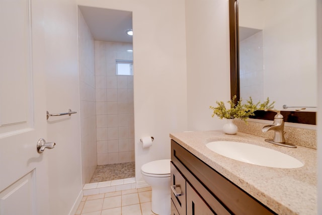 bathroom featuring tile patterned flooring, vanity, toilet, and a tile shower