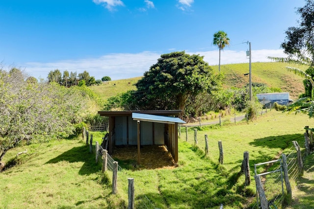 view of yard featuring an outdoor structure and a rural view