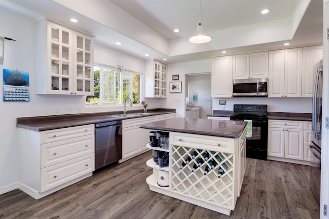 kitchen with white cabinetry, sink, stainless steel appliances, and a center island