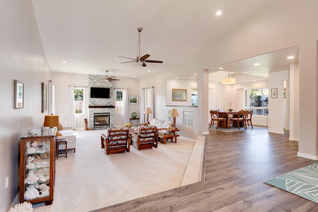 living room with hardwood / wood-style floors, a fireplace, high vaulted ceiling, and a healthy amount of sunlight