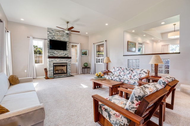 living room featuring ceiling fan, light colored carpet, and a fireplace