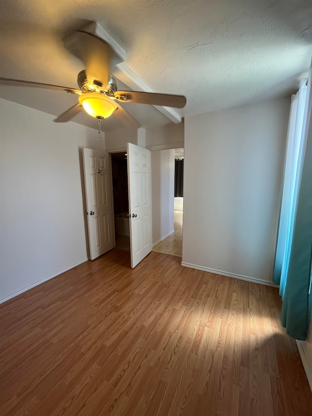 unfurnished bedroom featuring a textured ceiling, ceiling fan, and wood-type flooring